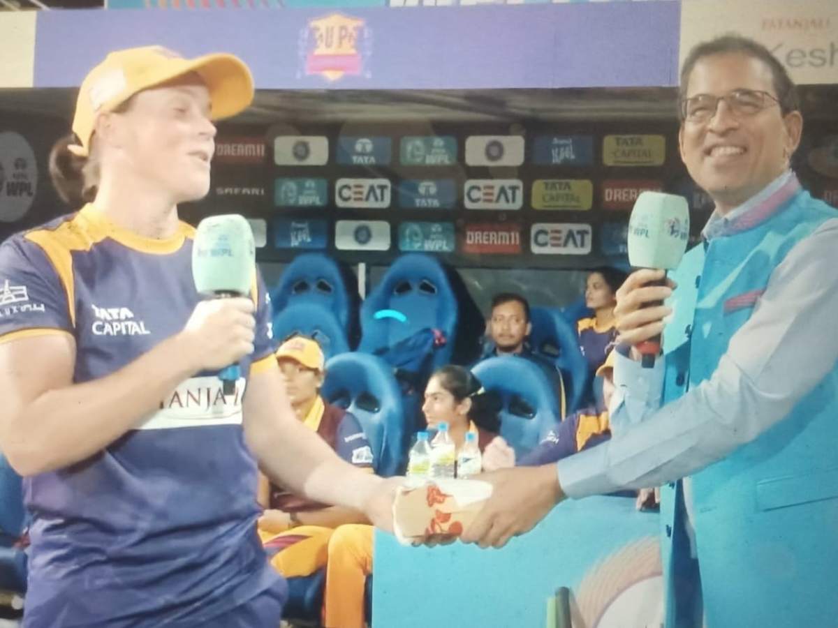 Why did Harsha Bhogle present a burger to Grace Harris?