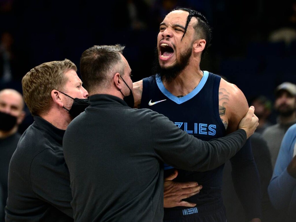 Dillon Brooks fired up as he is held by officials (via NBA)