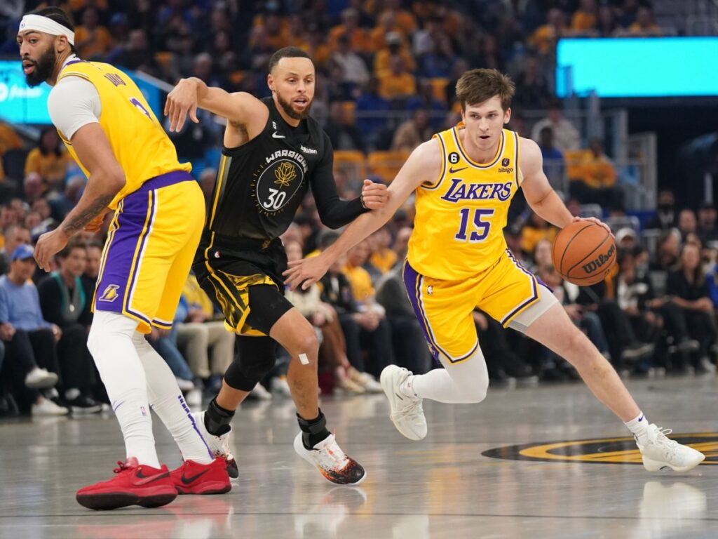 Los Angeles Lakers guard Austin Reaves (15) dribbles past Golden State Warriors guard Stephen Curry (30) (Via USA TODAY Sports)