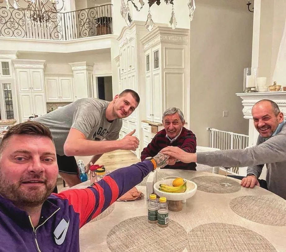 a group of men sitting around a table with food d