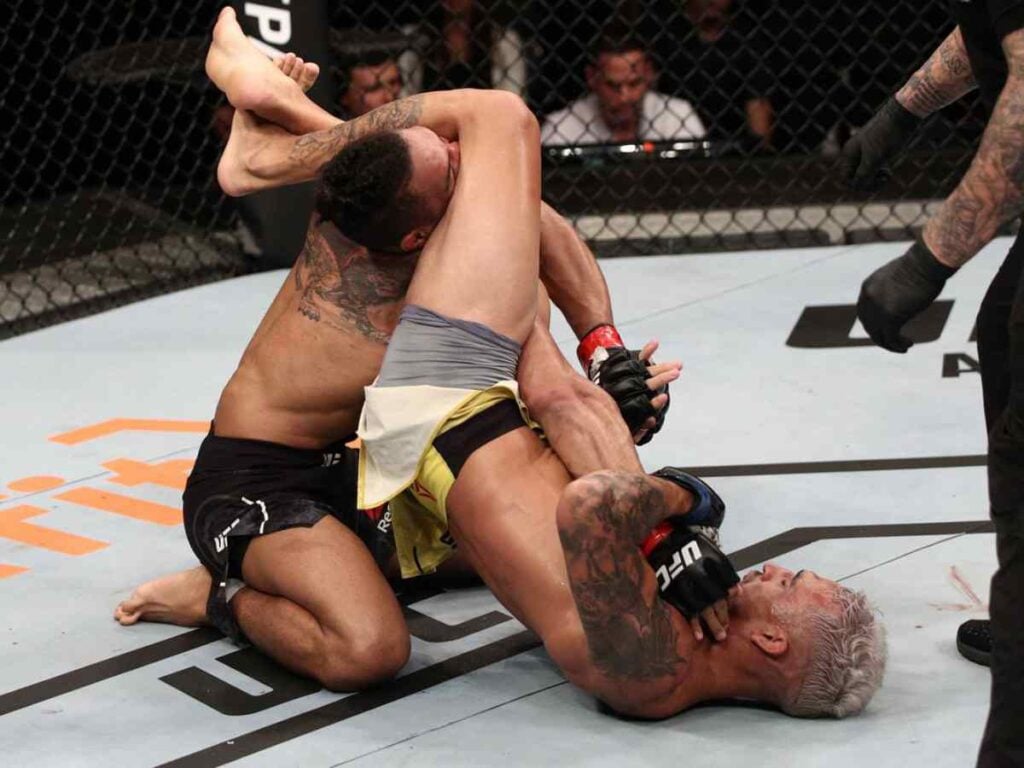 Charles Oliveira submitting his opponent with a Guillotine choke Image Courtesy MMA Mania