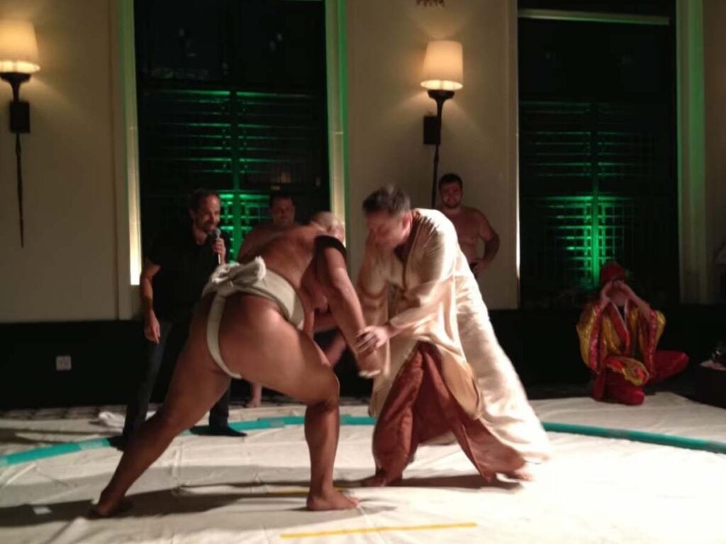 Elon Musk attempting to wrestle a Sumo wrestler