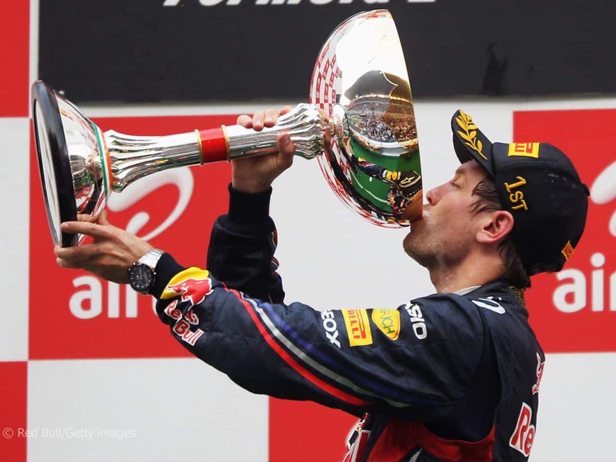 Sebastian Vettel drinks champagne from the winner's trophy after his first grand slam at Indian GP, 2011