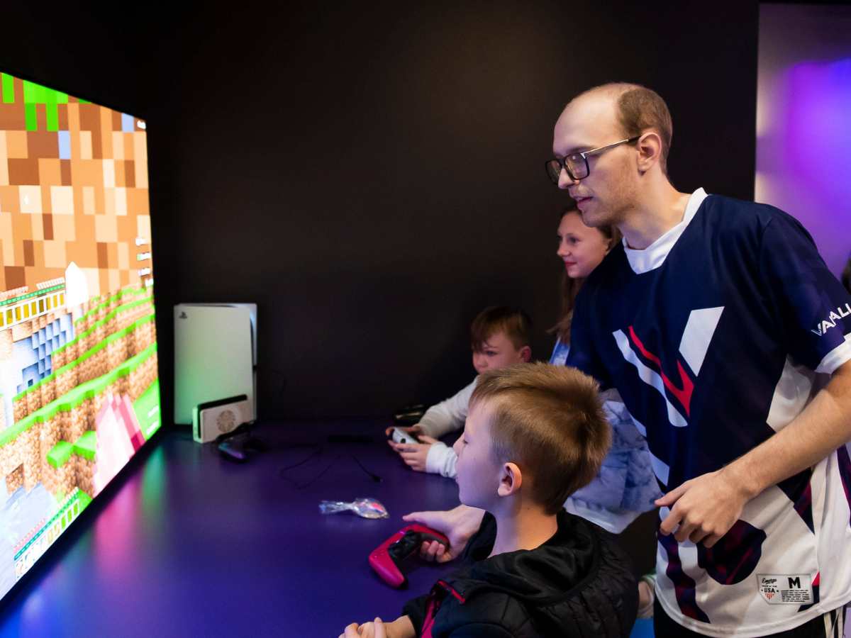 Hanover Evening Sun Connor Aultman helps a group of young gamers set up a controller to play Minecraft during a pre-grand opening event at Valhallan Esports Training on Thursday, Nov. 30, 2023, in Camp Hill. Aultman, 19, is a freshman esports management m