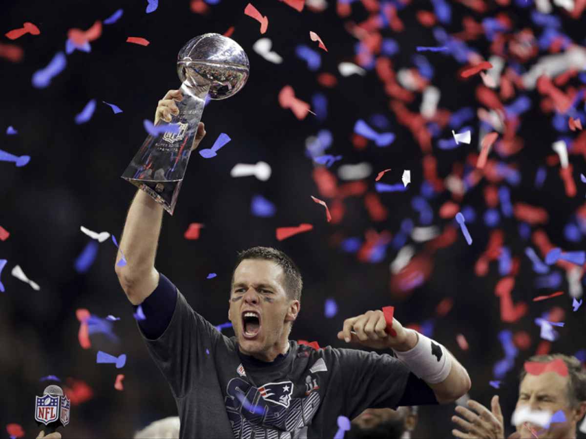 Tom Brady holding his first Super Bowl trophy