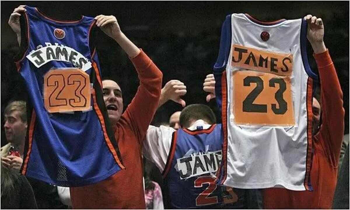 New York Knicks fans holding their jersey with LeBron James' name on the back (Via The New York Times)