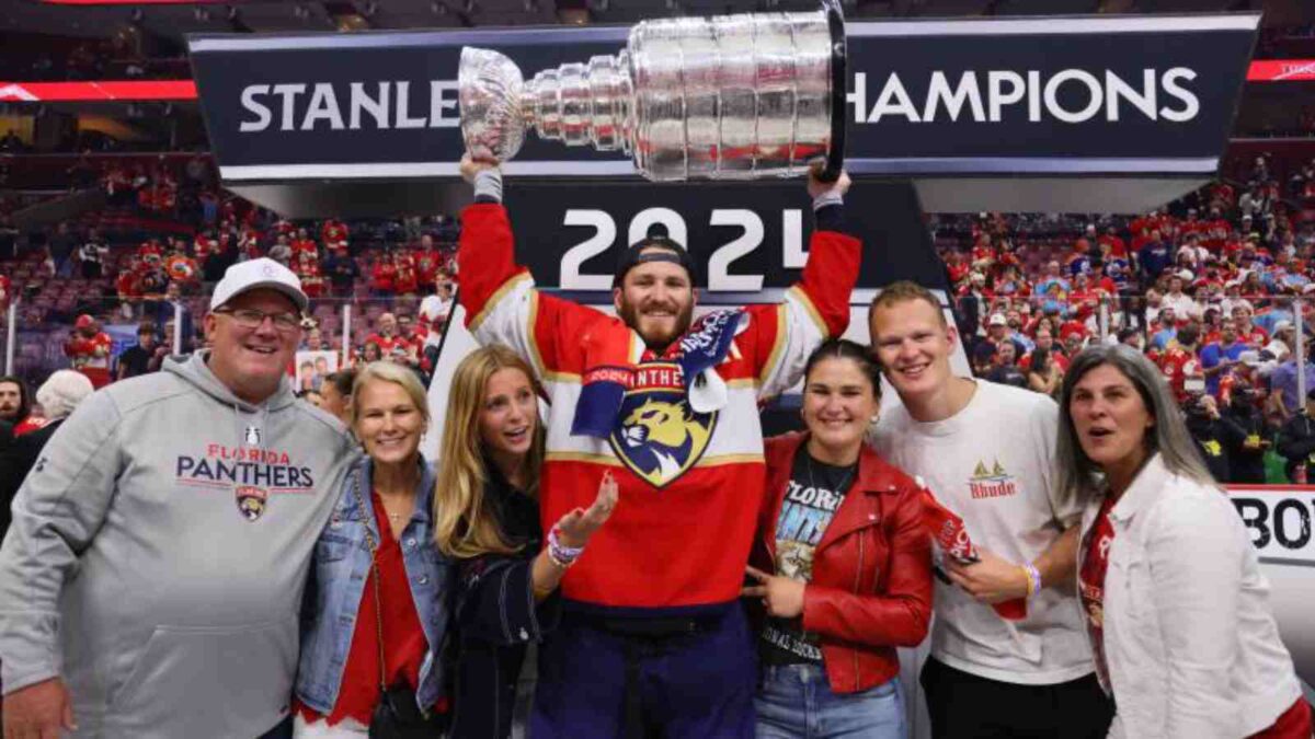 Matthew Tkachuk lifting Stanley Cup, standing beside his family