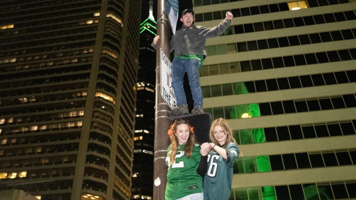 18-year-old Eagles fan tragically loses his life while celebrating Philly's playoff win 3 Eagles fans climbing poles in celebration